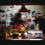 a man is making a drink in a dark room